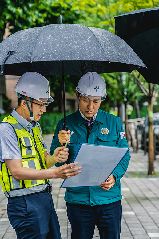 비 오는 날 우산을 들고 건설현장 담당자에게 설명을 듣고있는 오세훈 서울시장