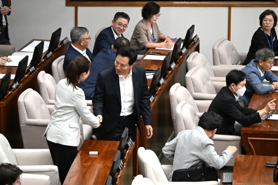 제324회 시의회 본회의에 입장하며 의원들과 인사하는 오세훈 서울시장