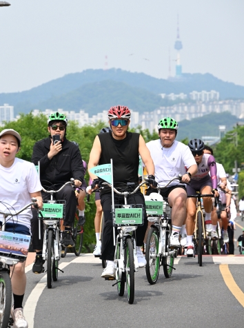사진1. 31일(토) ‘제2회 쉬엄쉬엄 한강 3종 축제’ 자전거 종목 참가한 오세훈 서울시장이 ‘투표합시다’ 깃발이 꽂힌 따릉이를 타고 한강 자전거도로를 달리고 있다.