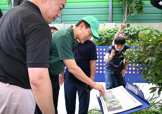 사진3. 오세훈 서울시장이 25일(금) 동대문구 청량꿈숲에 비치된 식물 정보 책자를 살펴보고 있다.