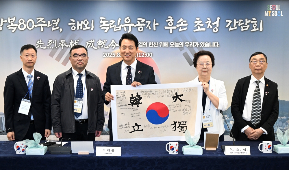 사진3. 오세훈 서울시장이 14일(목) 독립운동가 후손 초청 간담회에서 태극기에 서명하고 기념사진을 촬영하고 있다. 이날 오 시장을 비롯한 12인은 안중근 의사가 거사를 앞두고 12명의 동지와 함께한 ‘단지동맹_