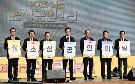 사진2. 오세훈 서울시장이 5일(수) 서울광장에서 열린 ‘2025 서울시 소상공인의 날 기념행사’에 참석해 카드문구를 들고 기념촬영하고 있다.
