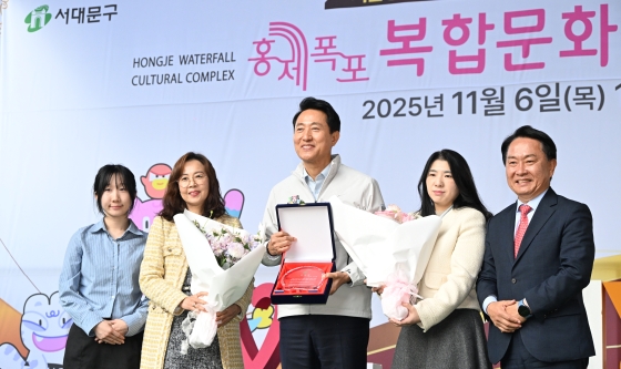 사진4. 오세훈 서울시장이 6일(목) 서대문구 홍제동 일대에서 열린 _홍제폭포 북합문화센터 개관식_에서 주민대표에게 감사패를 받고 기념촬영하고 있다.