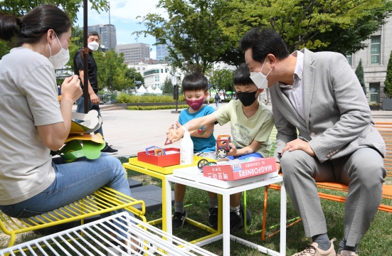 서울광장에서 책을 읽는 가족을 찾아 아이와 시간을 보내는 오세훈 서울시장-1